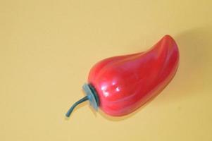 Peperone dolce isolato in plastica rossa su sfondo