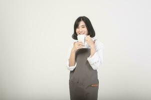 asiatico sorridente femmina imprenditore o barista indossare un grembiule al di sopra di bianca sfondo, concetto piccolo attività commerciale foto