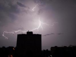 lampi e tuoni di notte in città piove foto