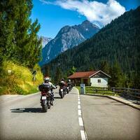 gruppo di bikers su il strada nel Alpi foto