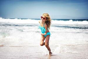 bambino ragazza in esecuzione su un' spiaggia foto
