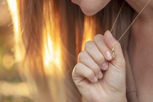 ragazza con un' bellissimo pendente su sua collo foto