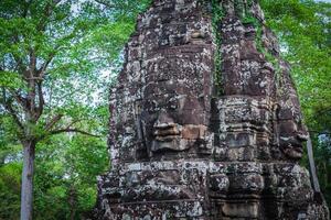 antiche facce di pietra del tempio bayon, angkor, cambogia foto