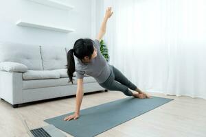 sottile donna praticante yoga su camera di sua condominio o casa. asiatico donna fare esercizi nel mattina. equilibrio, meditazione, rilassamento, calma, bene Salute, felice, relax, salutare stile di vita, dieta, sottile foto