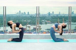 sottile donna praticante yoga su il balcone di sua condominio. asiatico donna fare esercizi nel mattina. equilibrio, meditazione, rilassamento, calma, bene Salute, felice, relax, salutare stile di vita concetto foto