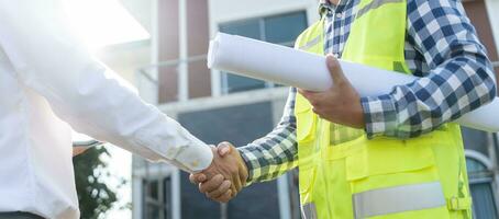 costruzione squadra mani tremante saluto inizio su Piano nuovo progetto contrarre nel ufficio centro a costruzione luogo, industria ,architettura, compagno, lavoro di squadra, accordo, proprietà, contatti. foto