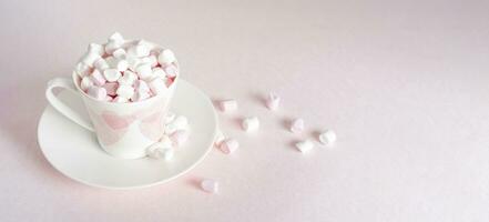 pastello pesca ancora vita con mini marshmallows nel porcellana tazza con rosa cuori, regalo per La madre di giorno, San Valentino giorno foto