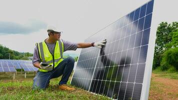 asiatico uomo ingegnere utilizzando digitale tavoletta mantenimento solare cellula pannelli Lavorando all'aperto su ecologico solare azienda agricola costruzione. foto