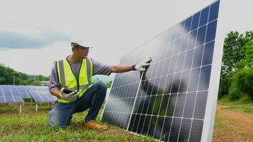 asiatico uomo ingegnere utilizzando digitale tavoletta mantenimento solare cellula pannelli Lavorando all'aperto su ecologico solare azienda agricola costruzione. foto