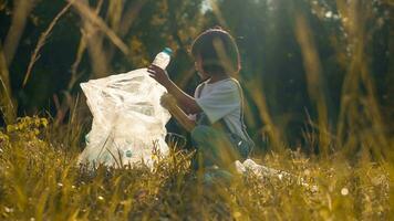 ragazzo ragazza collezione plastica spazzatura nel natura. ragazzo raccolta su spazzatura nel parco. foto