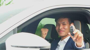 giovane asiatico uomo d'affari mostrando un' auto chiave dentro il suo nuovo elettrico veicolo. ev macchina. foto