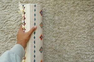 superiore Visualizza di mano rotolamento su nuovo tappeto. foto