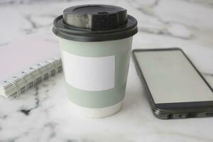 vuoto prendere lontano kraft caffè tazza, bloc notes e inteligente Telefono su tavolo foto