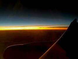 al di fuori finestra Visualizza di aereo con aereo ala e cielo di Alba sfondo. foto