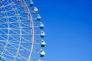 avvicinamento e Ritaglia tempozan gigante Ferris ruota su luminosa blu cielo sfondo con spazio per testi. foto