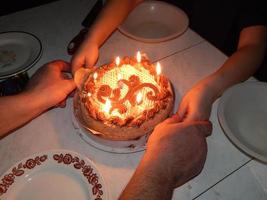 torta con candele accese per un compleanno figlia e papà foto