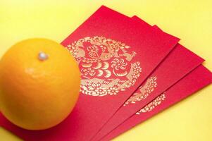Cinese nuovo anno rosso pacchetti e arancia su giallo copertina sfondo. Cinese festivo stagione concetto e copia spazio. foto