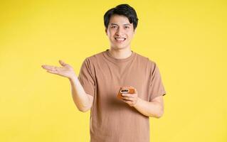 ritratto di asiatico uomo in posa su giallo sfondo foto