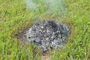 un falò con piante secche sta bruciando su un terreno con fuoco e fumo foto