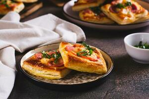 piazza mini Pizza con pomodoro, salsiccia e formaggio su un' piatto per un' merenda foto