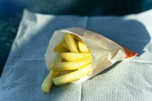 gustoso e croccante francese patatine fritte nel un' tradizionale carta tazza, Perfetto per spuntini e veloce cibo Gli amanti foto