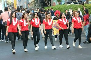 surabaya, Indonesia, 29 ottobre 2023 - gruppo di giovane adulti a piedi nel uniforme rosso camicie all'aperto foto