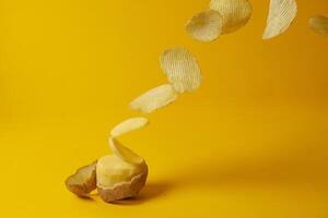 le patatine volano su uno sfondo giallo, il processo di produzione delle patatine, la levitazione del fast food