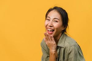 giovane donna asiatica con espressione positiva, sorriso ampiamente, vestita con abiti casual e guardando la telecamera su sfondo giallo. felice adorabile donna felice esulta successo. concetto di espressione facciale. foto