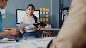 felici giovani uomini d'affari e donne d'affari dell'Asia incontro di brainstorming di alcune nuove idee sul progetto al suo partner che lavora insieme pianificazione della strategia di successo godetevi il lavoro di squadra in un piccolo ufficio moderno. foto