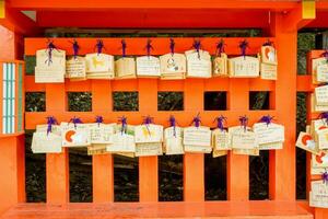 kyoto, Giappone, Maggio 19, 2018 - desiderando di legno etichetta con benedizione testo a partire dal persone e turista su rosso di legno polo a fushimi inari santuario. foto
