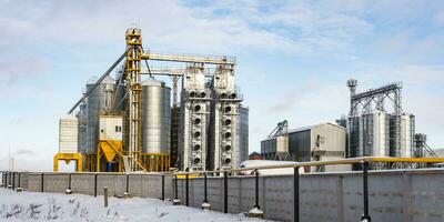 moderno agro-trasformazione pianta per in lavorazione e silos per essiccazione pulizia e Conservazione di agricolo prodotti, Farina, cereali e grano nel neve di inverno campo foto