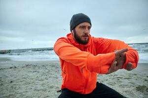 avvicinamento di concentrato giovane brunetta barbuto uomo guardare avanti mentre esercizio all'aperto, va nel per sport ogni mattina. maschio fitness jogging formazione benessere concetto foto