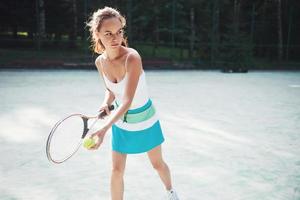 una bella donna che indossa un campo da tennis sportivo sul campo foto