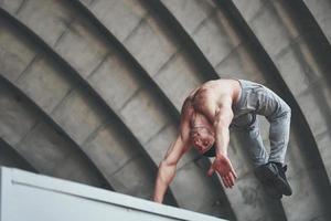 il ragazzo nel parco all'aperto pratica parchi, adrenalina alta. foto