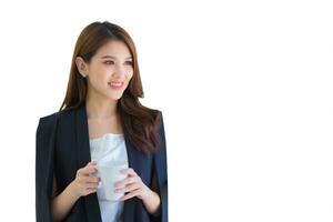 giovane professionale ufficio asiatico donna hold bianca tazza nel mani fiducioso mentre lei opera a partire dal ufficio mentre isolato su bianca sfondo. foto