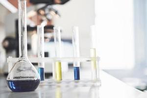 pallone con tappo di sughero da laboratorio liquido rosa viola blu sul tavolo nel test del fluido del laboratorio di prova