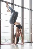 una bella donna di yoga che pratica in una spaziosa palestra leggera foto