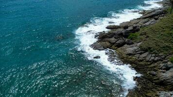 aereo Visualizza di mare onde Crashing su rocce scogliera nel il blu oceano. superiore Visualizza di costiero rocce nel Phuket oceano. paesaggio Visualizza punto di laem phromthep capo nel il mattina. foto