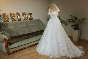 Da donna nozze vestito nel casa camera su manichino, preparazione per nozze cerimonia, della sposa mattina a casa foto