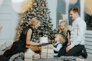 allegro e contento famiglia con Natale i regali festeggiare compleanno per Due anni. bambini siamo avendo divertimento. amorevole famiglia con i regali nel il camera. foto