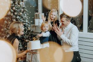 allegro e contento famiglia con Natale i regali festeggiare compleanno per Due anni. bambini siamo avendo divertimento. amorevole famiglia con i regali nel il camera. foto