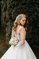 foto di il sposa nel un' nozze vestito con maniche, un' bellissimo acconciatura e un' tiara su sua testa, Tenere un' mazzo di fiori dietro a sua Indietro.