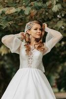 foto di il sposa nel un' nozze vestito con maniche, un' bellissimo acconciatura e un' tiara su sua testa, con un' mazzo di fiori nel sua mani