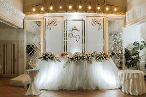 decorato tavolo di il sposa e sposo nel il nozze sala. preparazione per il nozze celebrazione foto