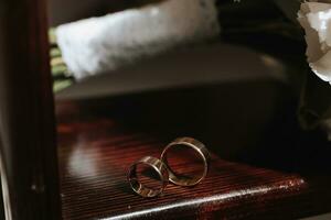 Due d'oro nozze anelli su un' di legno In piedi, avvicinamento foto