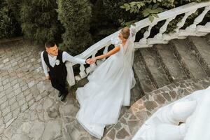 giovane bellissimo nozze coppia Tenere mani a piedi nel il giardino, foto tiro a partire dal sopra.