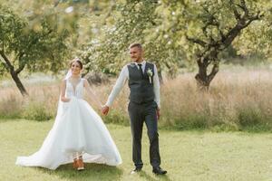 un' bellissimo nozze, un' bellissimo coppia nel amore, a piedi su il sfondo di un' verde giardino con alto verde alberi. alto qualità foto