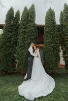 un' bellissimo nozze, un' bellissimo coppia nel amore, ridendo e baci contro il sfondo di un' verde giardino. alto qualità foto