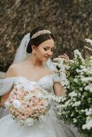 ritratto di un' bellissimo sposa nel un' bianca nozze vestito con un' lungo treno con un' moderno acconciatura e un' velo a piedi nel il giardino. nozze concetto foto