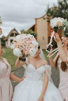 gruppo ritratto di il sposa e damigelle d'onore avendo divertimento. nozze. un' sposa nel un' nozze vestito e sua amici nel rosa vestiti su il nozze giorno. elegante nozze nel polvere colore. concetto di matrimonio. foto